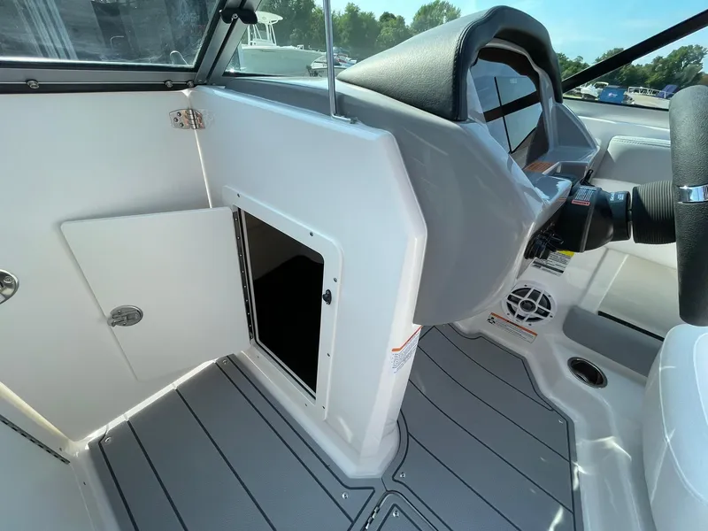 Slide: The Image of 2024 Chaparral 21 SSi OB boat interior, showing storage compartment and helm area. - 25