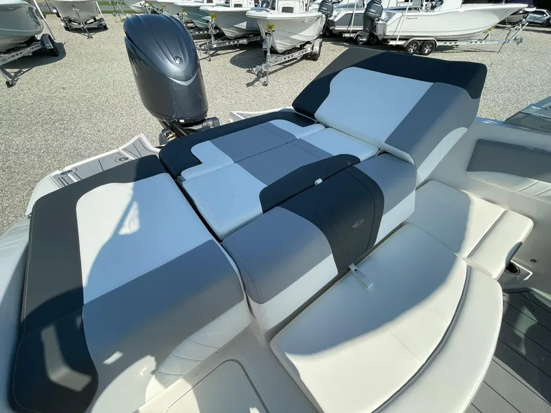 Slide: The Image of 2024 Chaparral 21 SSi OB boat with cushioned seating and outboard motor. - 39