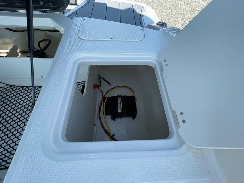 Slide: The Image of 2024 Chaparral 21 SSi OB boat storage compartment with battery and wiring. - 45