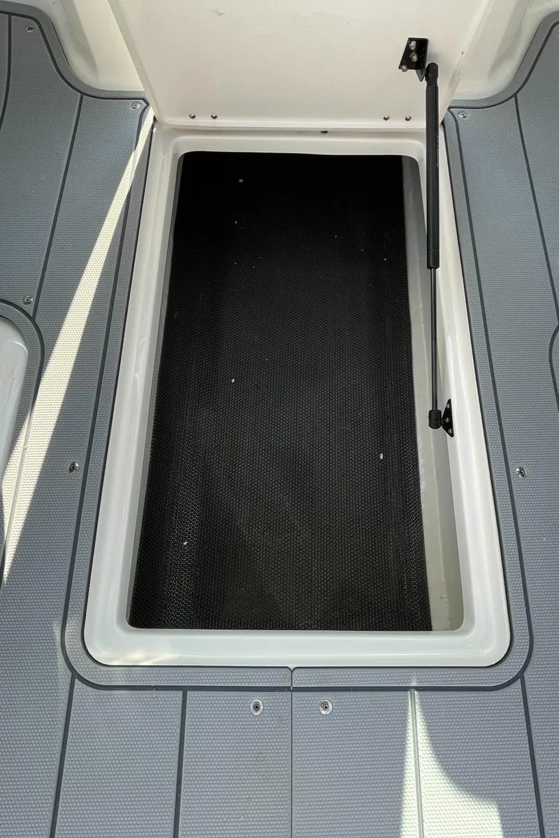 Slide: The Image of 2024 Chaparral 21 SSi OB boat storage compartment with open hatch. - 48
