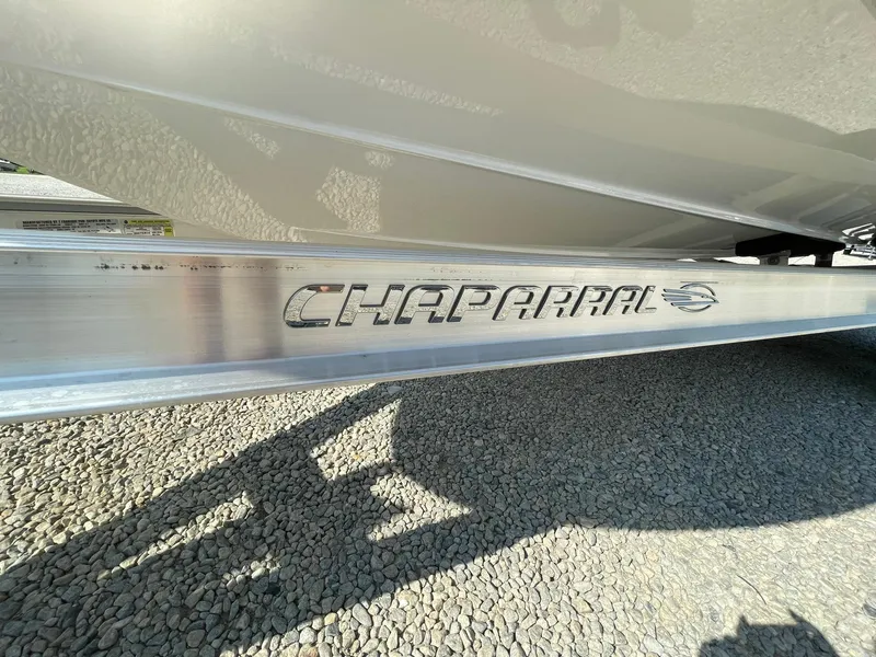 Slide: The Image of 2024 Chaparral 21 SSi OB boat trailer close-up on gravel surface. - 5