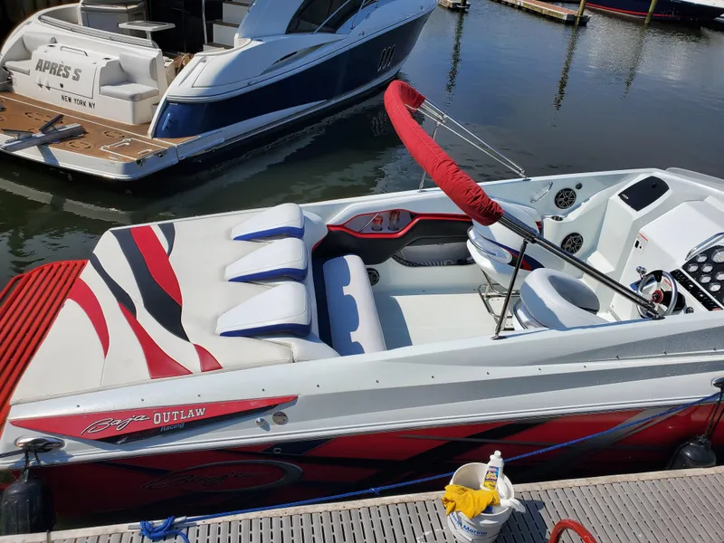 Slide: The Image of 2007 Baja Outlaw 35 speedboat docked, featuring sleek red and white design. - 1