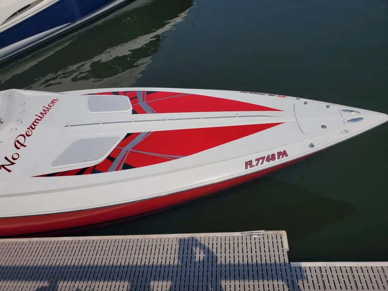 Slide: The Image of 2007 Baja Outlaw 35 speedboat with red and white design docked at marina. - 4