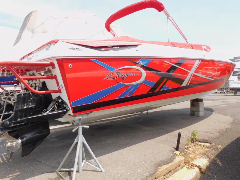 Slide: The Image of 2007 Baja Outlaw 35 speedboat with vibrant red, blue, and black graphics on a trailer. - 7