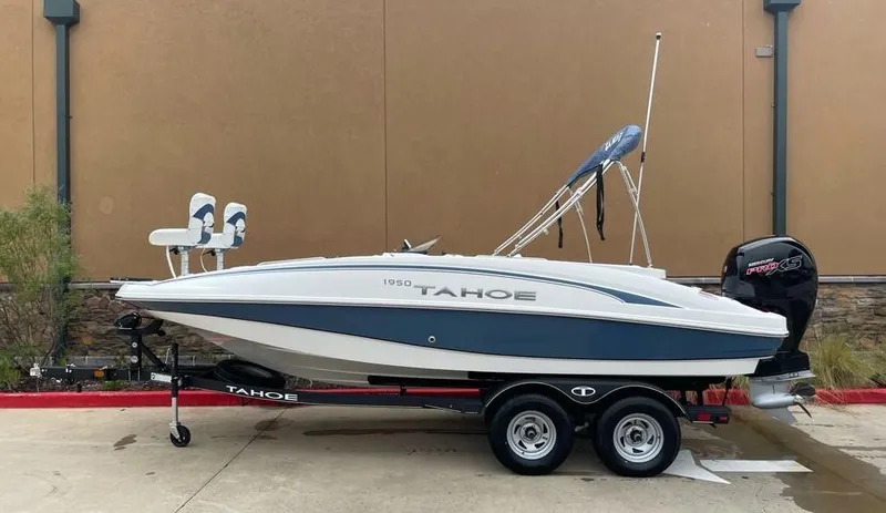Slide: The Image of 2024 Tahoe 1950 boat on trailer, parked outdoors, side view. - 0