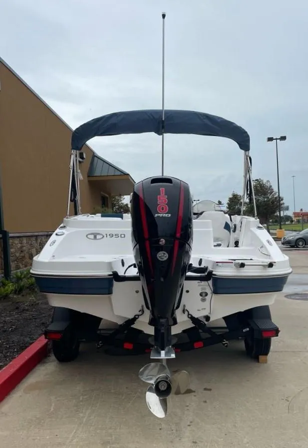Slide: The Image of 2024 Tahoe 1950 boat with outboard motor, parked outdoors. - 3