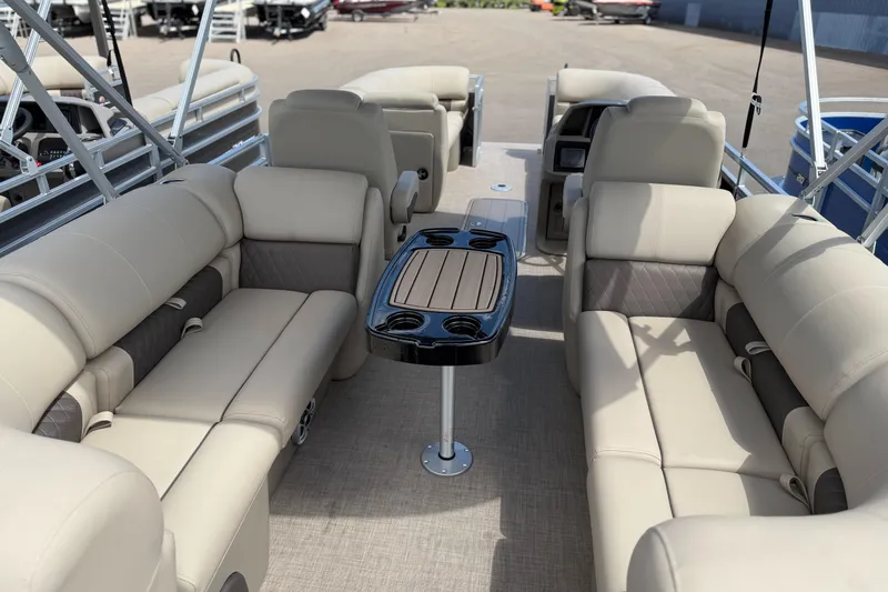 Slide: The Image of 2024 Sun Tracker Party Barge 20 DLX interior with beige seating and central table. - 4