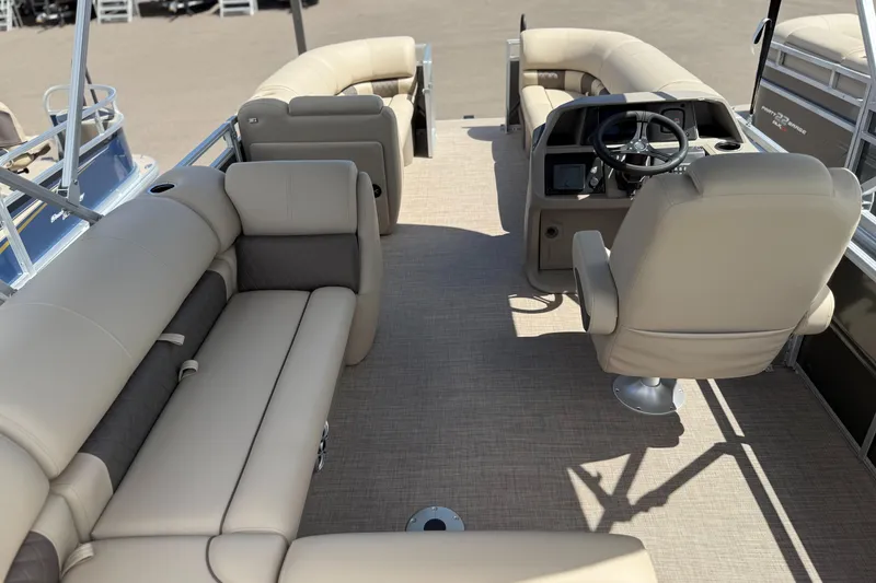 Slide: The Image of 2024 Sun Tracker Party Barge 20 DLX interior with beige seating and steering console. - 5