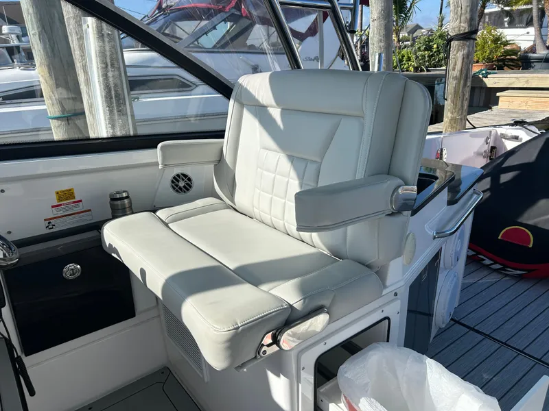 Slide: The Image of Captain's chair on a 2019 Everglades 340DC boat, docked at a marina. - 10