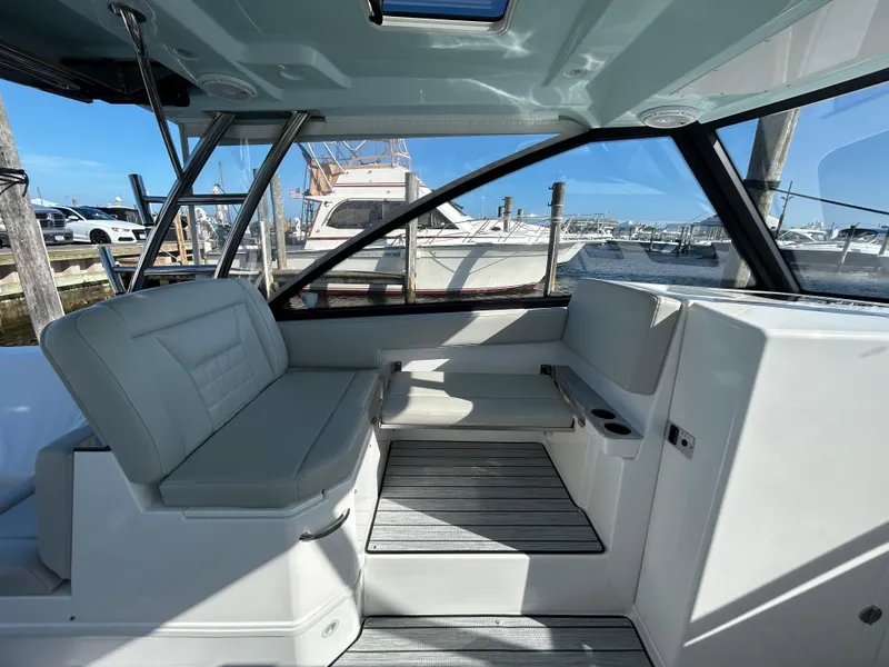 Slide: The Image of Interior of a 2019 Everglades 340DC boat with docked yachts in the background. - 11