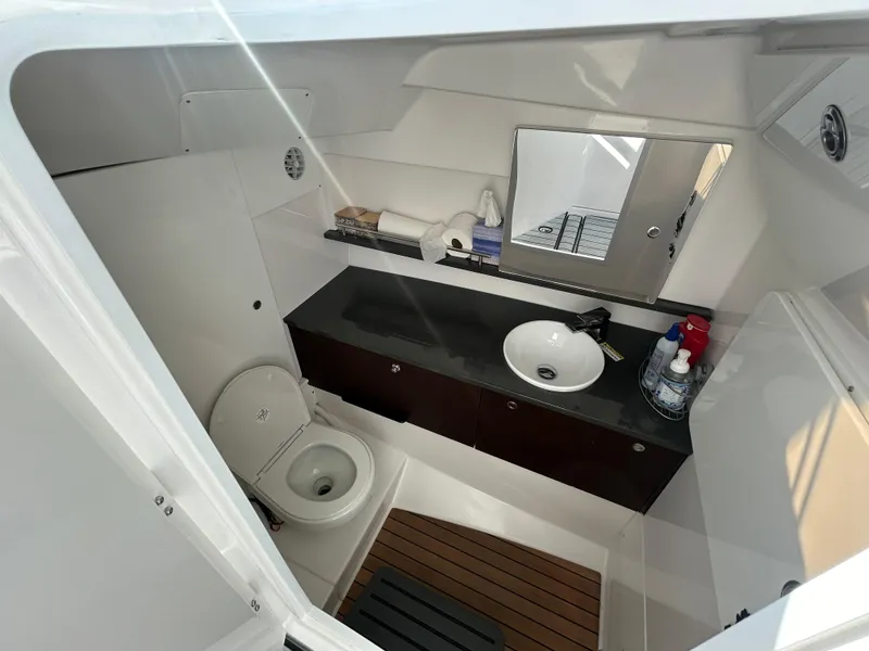 Slide: The Image of 2019 Everglades 340DC boat bathroom with sink, toilet, and mirror. - 13