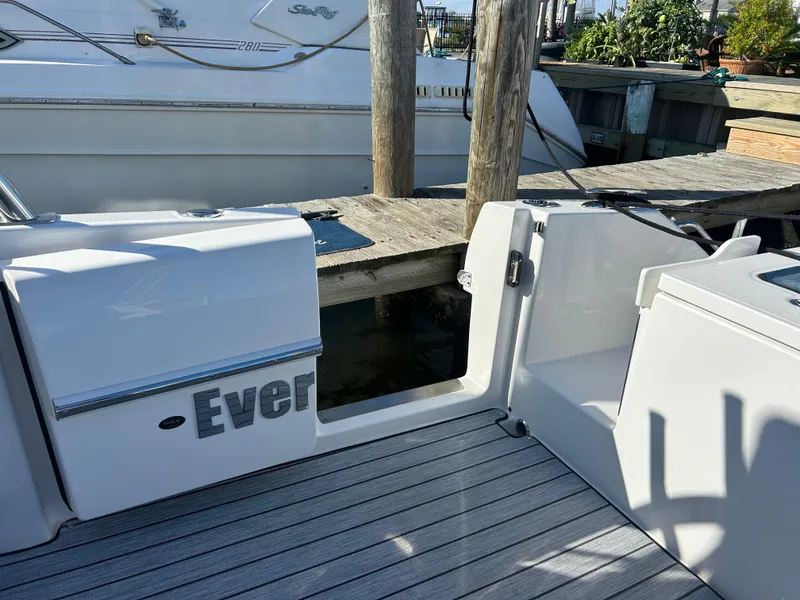 Slide: The Image of 2019 Everglades 340DC boat docked, showing open transom door and deck. - 18