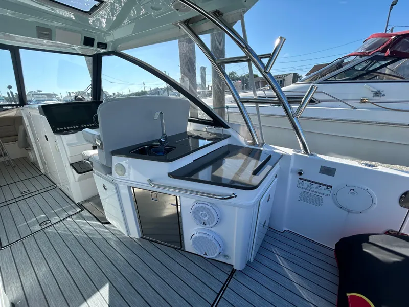 Slide: The Image of 2019 Everglades 340DC boat interior with kitchenette and seating area. - 25