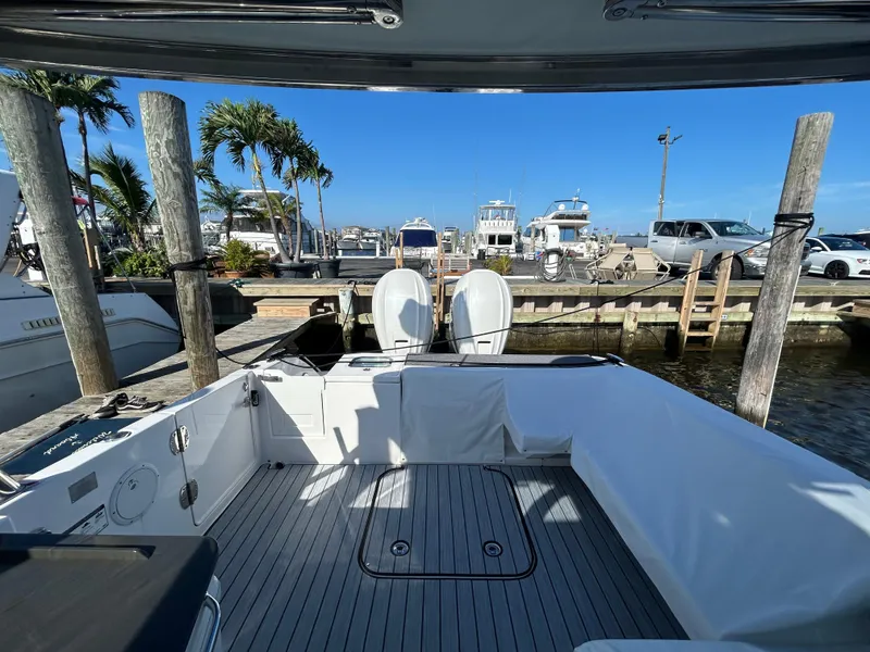 Slide: The Image of 2019 Everglades 340DC boat docked at a marina with twin outboard engines. - 27