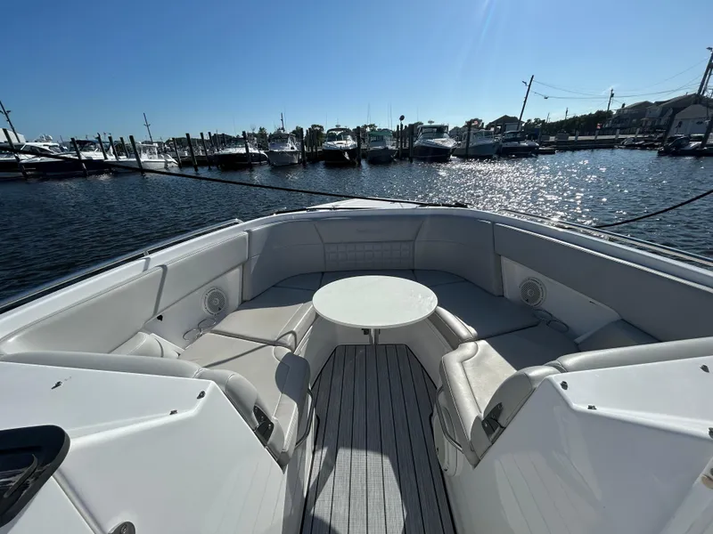 Slide: The Image of 2019 Everglades 340DC boat with spacious seating area and table, docked at a marina. - 3