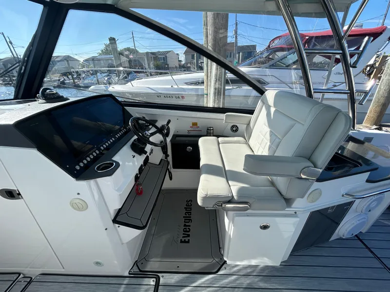 Slide: The Image of 2019 Everglades 340DC boat helm with white captain's chair and control panel. - 9