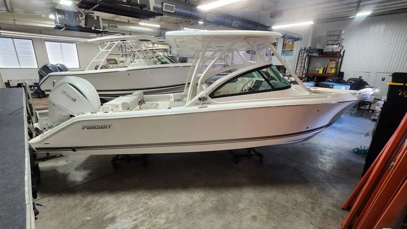 The Image of 2024 Pursuit DC 246 Dual Console boat in indoor storage facility. - 0