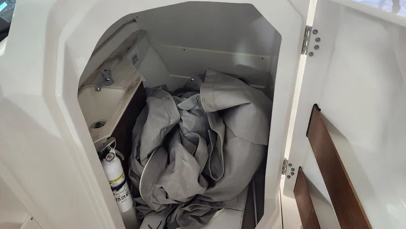 Slide: The Image of 2024 Pursuit DC 246 Dual Console interior storage with fire extinguisher and fabric. - 10