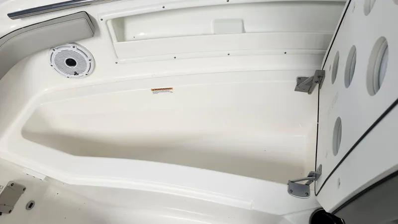 Slide: The Image of 2024 Pursuit DC 246 Dual Console interior storage compartment with speaker and door. - 12