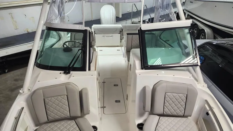 Slide: The Image of 2024 Pursuit DC 246 Dual Console boat interior with cushioned seating and windshield. - 14