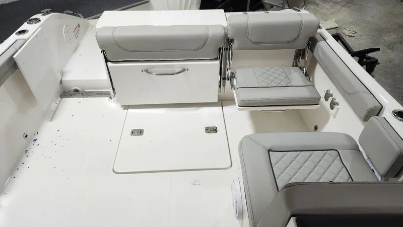 Slide: The Image of 2024 Pursuit DC 246 Dual Console boat interior with gray seating and storage. - 4