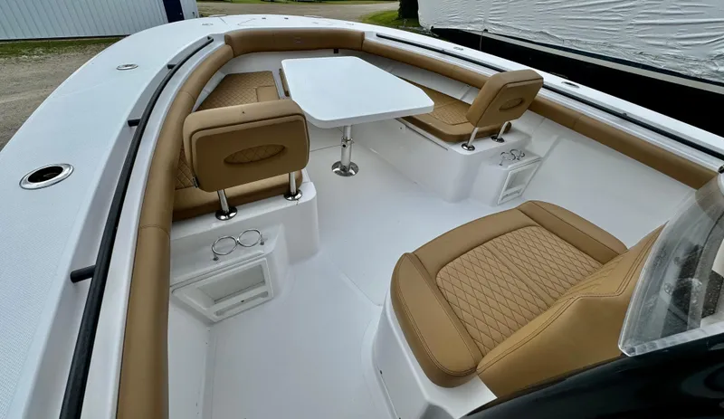 Slide: The Image of 2020 Southport 33 FE boat interior with tan leather seating and a white table. - 11