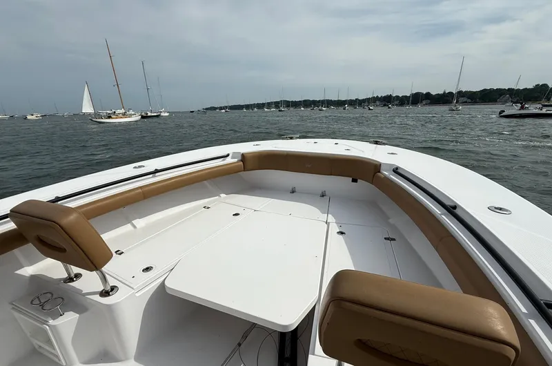 Slide: The Image of 2020 Southport 33 FE boat with tan seating, on a calm waterway with sailboats. - 13