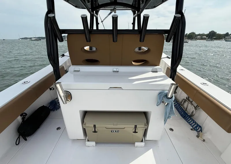 Slide: The Image of 2020 Southport 33 FE boat interior with storage and cooler, docked on a calm waterway. - 17