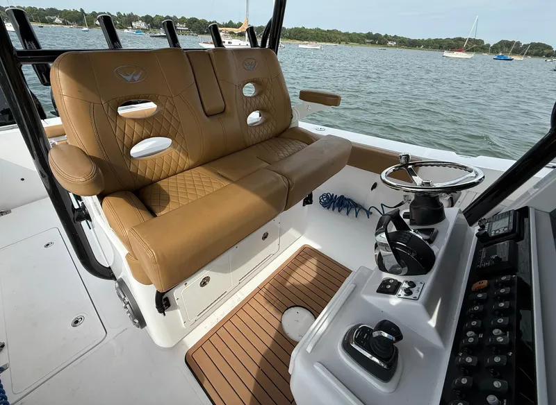 Slide: The Image of 2020 Southport 33 FE boat interior with tan seating and steering console on the water. - 8