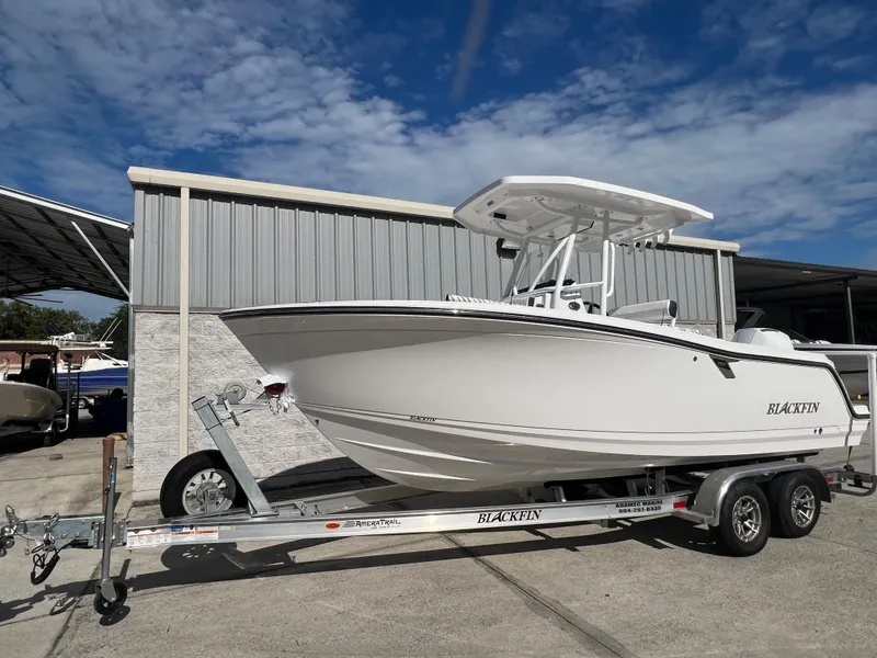 The Image of 2025 Blackfin 222 CC boat on a trailer, parked outside under a blue sky. - 0