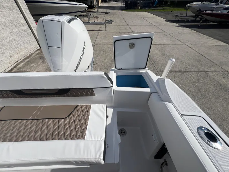 Slide: The Image of 2025 Blackfin 222 CC boat with Mercury outboard engine and open storage compartments. - 10