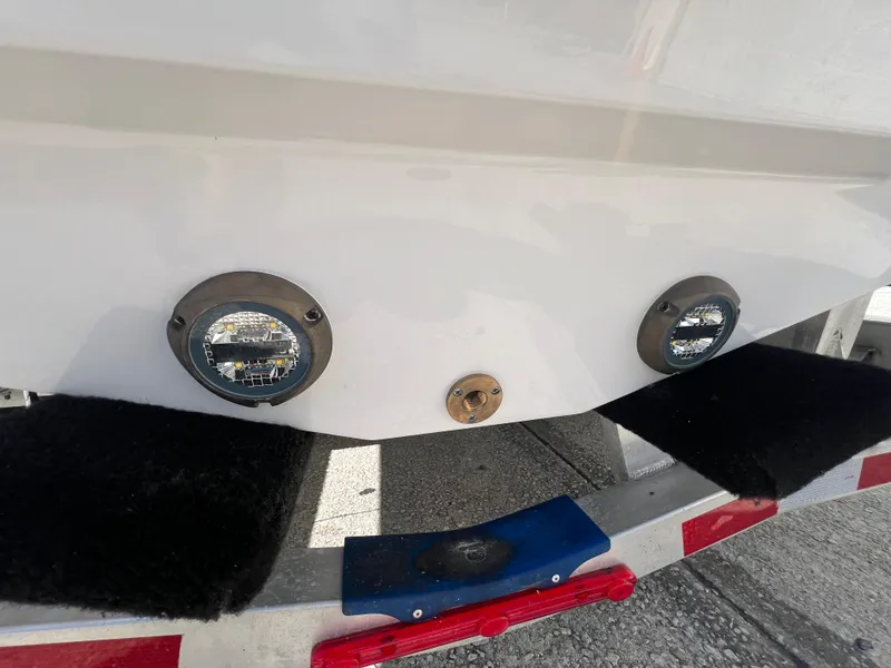 Slide: The Image of 2025 Blackfin 222 CC boat on trailer, showing underwater lights and drain plug. - 18