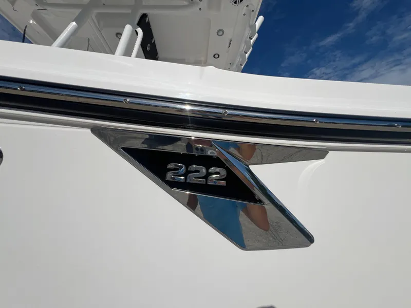 Slide: The Image of 2025 Blackfin 222 CC boat emblem against a clear blue sky. - 30