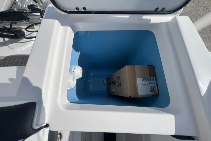 Slide: The Image of 2025 Blackfin 222 CC storage compartment with a box inside. - 35