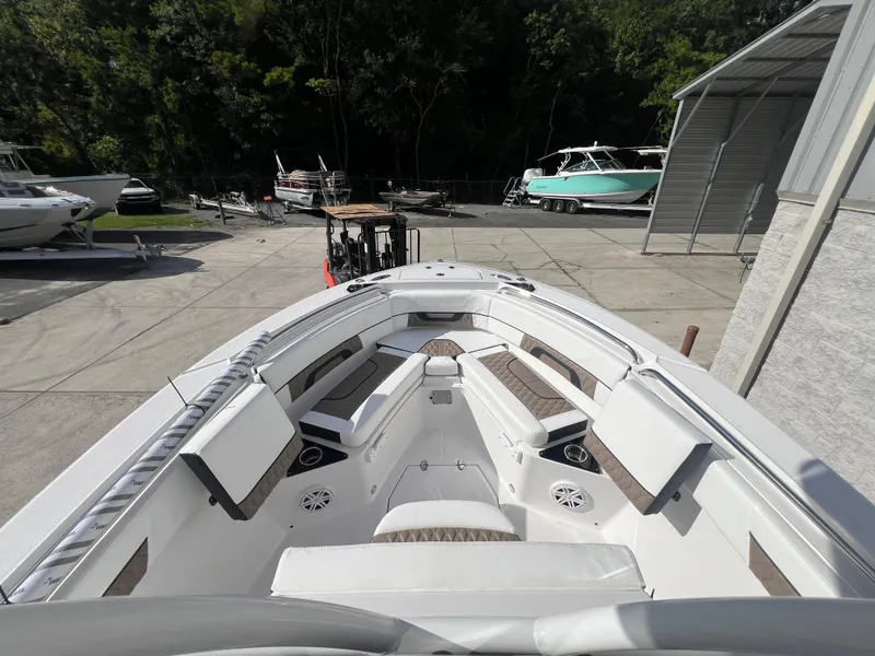 Slide: The Image of 2025 Blackfin 222 CC boat with spacious seating and modern design in a marina. - 4