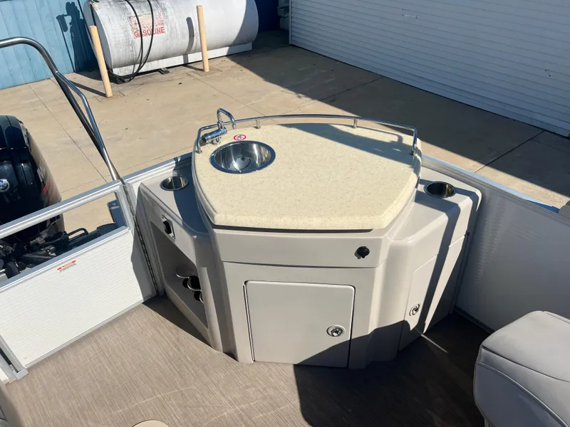 Slide: The Image of 2017 Bennington 24SPDX boat with a built-in sink and storage compartments. - 17