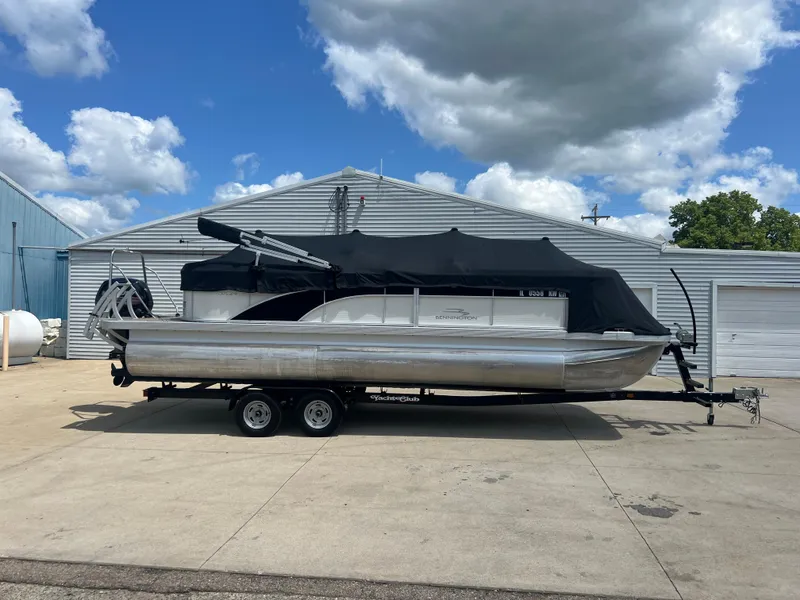 Slide: The Image of 2017 Bennington 24SPDX pontoon boat on a trailer, covered with a black tarp. - 19