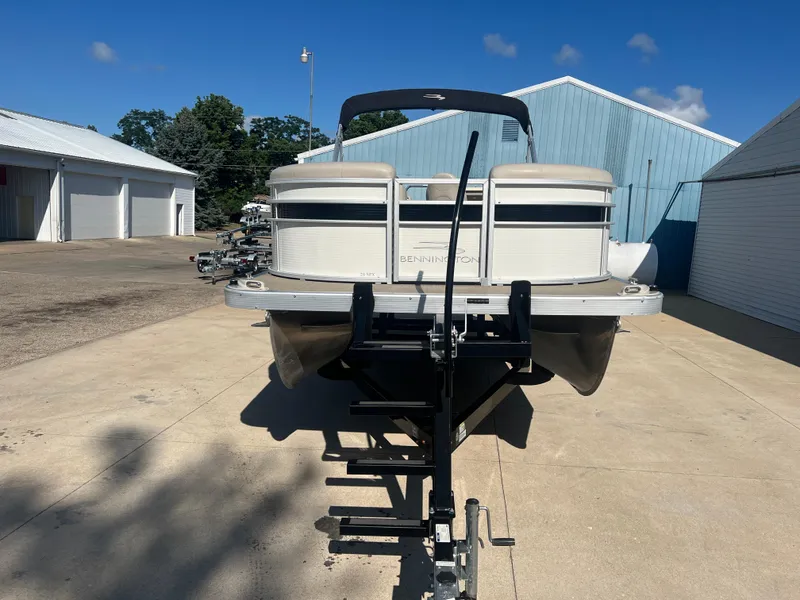 Slide: The Image of 2017 Bennington 24SPDX pontoon boat on a trailer in a marina. - 3