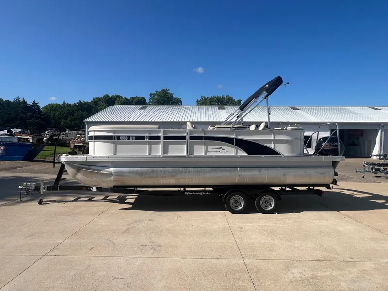 Slide: The Image of 2017 Bennington 24SPDX pontoon boat on a trailer in a marina. - 5