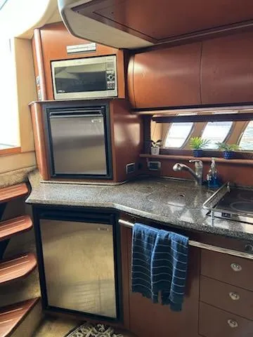 Slide: The Image of 2007 Sea Ray 380 Sundancer yacht kitchen with modern appliances and sleek design. - 10