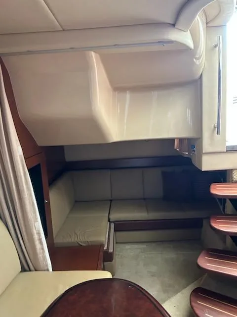 Slide: The Image of 2007 Sea Ray 380 Sundancer interior with beige seating and wooden accents. - 11
