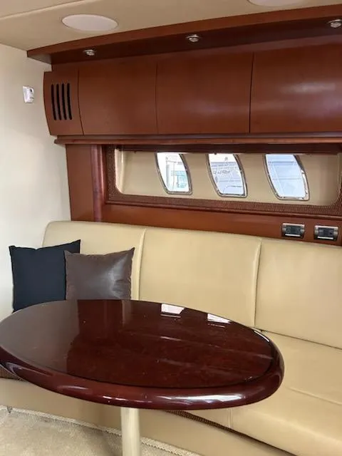 Slide: The Image of Interior of 2007 Sea Ray 380 Sundancer with beige seating and wooden table. - 8