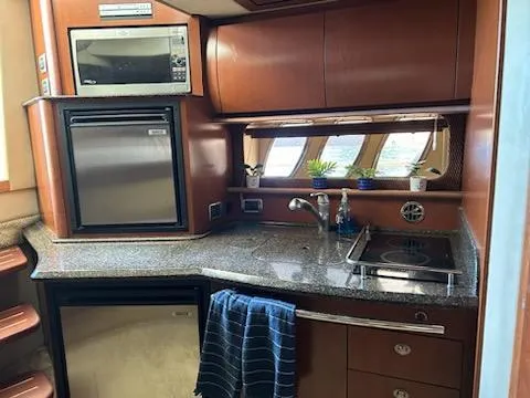Slide: The Image of 2007 Sea Ray 380 Sundancer kitchen with microwave, fridge, and stove. - 9