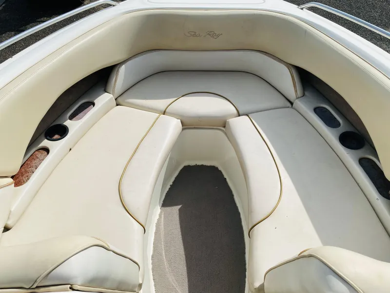 Slide: The Image of 1997 Sea Ray 230 boat interior with white cushioned seating. - 10