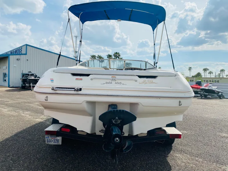 Slide: The Image of 1997 Sea Ray 230 boat with blue canopy, rear view in a parking lot. - 3