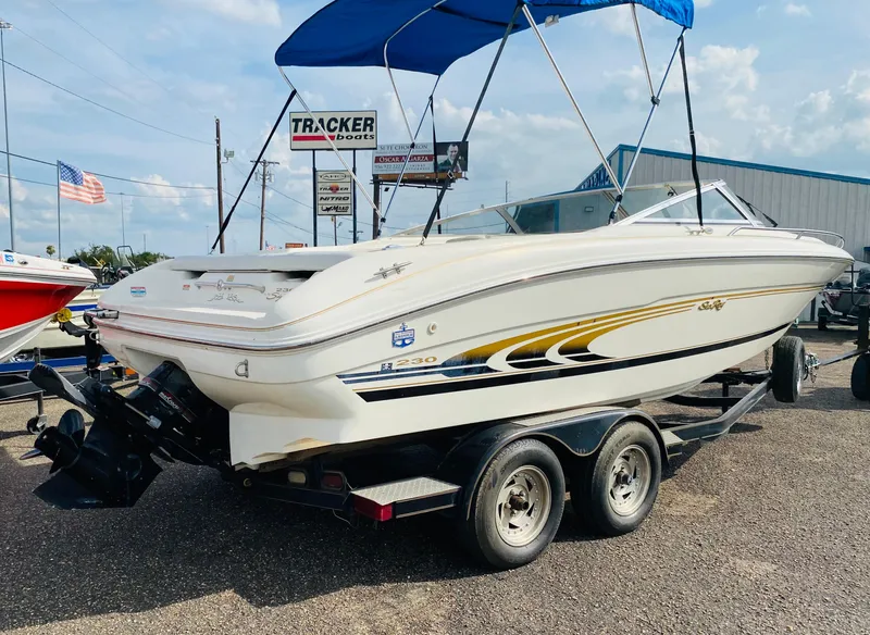 Slide: The Image of 1997 Sea Ray 230 boat on a trailer with blue canopy. - 4