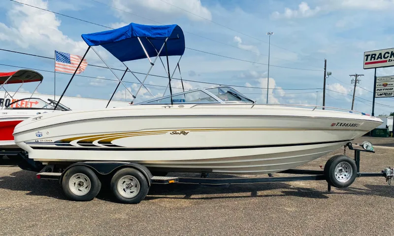 Slide: The Image of 1997 Sea Ray 230 boat on a trailer with blue canopy. - 5