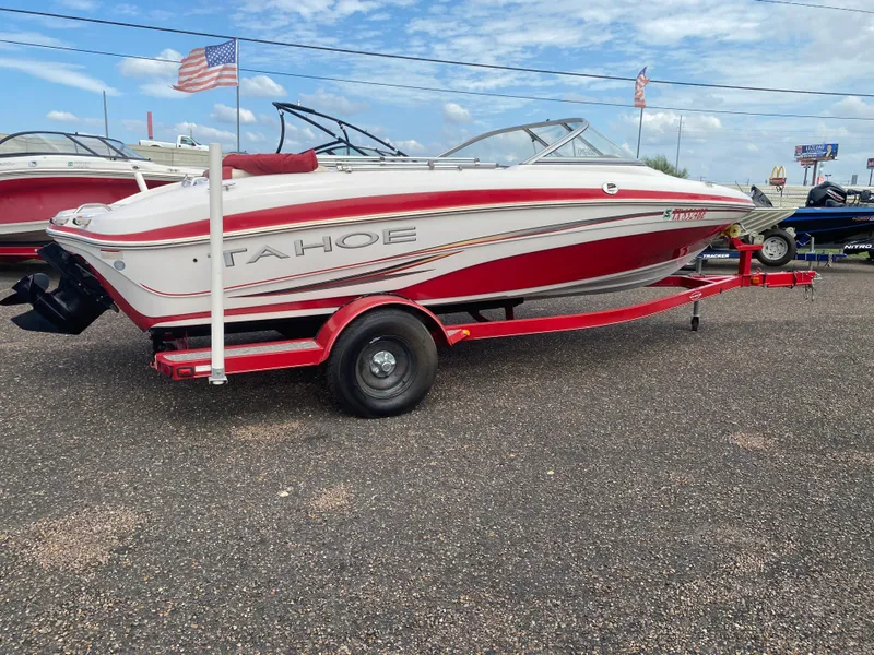 Slide: The Image of 2010 Tahoe Q5i boat on a red trailer, parked outdoors. - 4