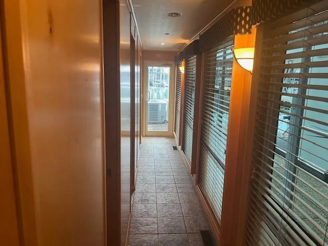 Slide: The Image of Interior hallway of a 2007 Thoroughbred houseboat with wooden walls and large windows. - 13