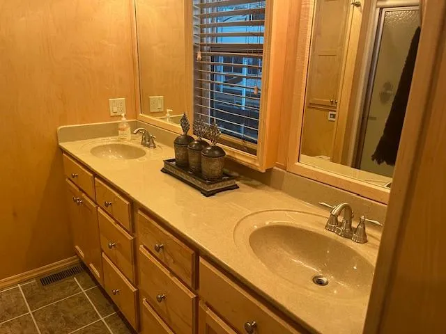 Slide: The Image of Double sink vanity in 2007 Thoroughbred houseboat bathroom with wooden cabinets and decorative items. - 16